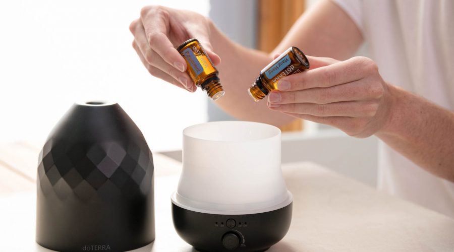 person putting essential oils into a diffuser
